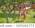 The children are playing with a toy turtle that sprays water.  143142173