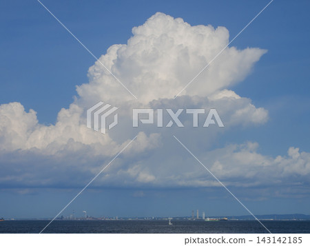 夏日景色,藍天白雲,高聳的積雨雲,帆船在海面上航行,遠處是工廠。 夏日景色,藍天白雲,高聳的積雨雲,帆船在海面上航行,遠處是工廠。 143142185