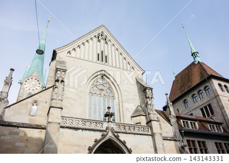 A historic church with a clock tower bathed in bright sunlight – the cityscape of Zurich, Switzerland. A historic church with a clock tower bathed in bright sunlight – the cityscape of Zurich, Switzerland. 143143331