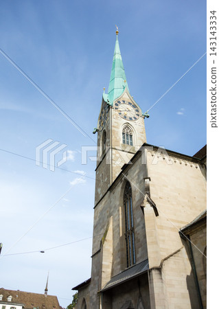 A historic church with a clock tower bathed in bright sunlight – the cityscape of Zurich, Switzerland. A historic church with a clock tower bathed in bright sunlight – the cityscape of Zurich, Switzerland. 143143334