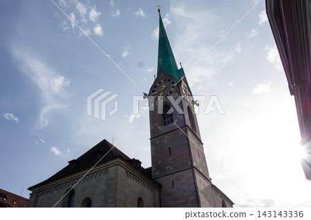 A historic church with a clock tower bathed in bright sunlight – the cityscape of Zurich, Switzerland. A historic church with a clock tower bathed in bright sunlight – the cityscape of Zurich, Switzerland. 143143336