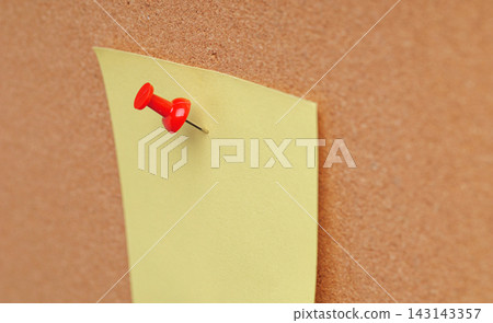 Blank yellow paper sheet mockup pinned on corkboard texture background for message and note 143143357