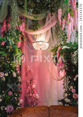 Wooden slab bench surrounded by floral arches and glowing crystal chandelier Wooden slab bench surrounded by floral arches and glowing crystal chandelier 143143370
