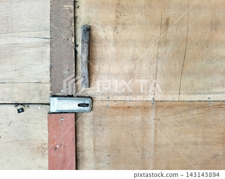 Industrial plywood panels joined with metal latch for construction site storage. 143143894