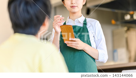 餐廳服務生正接受顧客點單。 餐廳服務生正接受顧客點單。 143144066