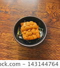 A superb sea urchin rice bowl that looks stunning on a Japanese-style wooden table (with space above for adding text). 143144764