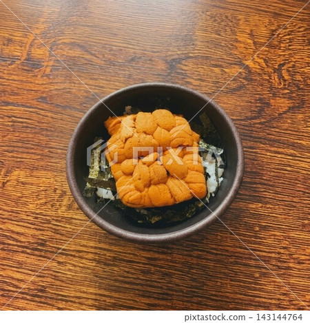 精美的海膽飯碗,擺在日式木桌上顯得格外賞心悅目(上方留有空間可添加文字)。 精美的海膽飯碗,擺在日式木桌上顯得格外賞心悅目(上方留有空間可添加文字)。 143144764