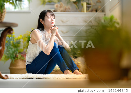 一位年輕女子正在祈禱 一位年輕女子正在祈禱 143144845