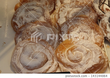 Ensaimadas, traditional mallorcan spiral pastries with powdered sugar Ensaimadas, traditional mallorcan spiral pastries with powdered sugar 143144864