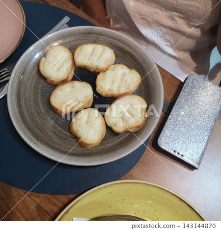 Toasted bread appetizers with cheese on a plate Toasted bread appetizers with cheese on a plate 143144870
