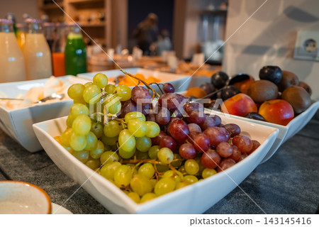 Hotel breakfast buffet bowls with grapes, apricots, plums in Oberlech Hotel breakfast buffet bowls with grapes, apricots, plums in Oberlech 143145416