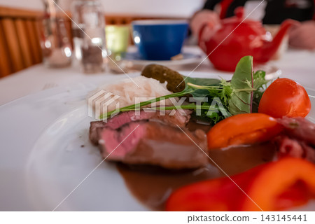 Medium rare sliced beef with arugula and sauce at Oberlech hotel Medium rare sliced beef with arugula and sauce at Oberlech hotel 143145441
