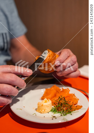 Butter spread on croissant with smoked salmon in Oberlech, Austria Butter spread on croissant with smoked salmon in Oberlech, Austria 143145609