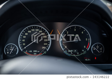 Close up BMW X5 instrument cluster shows speedometer to 260 kmh and tachometer to 7000 rpm, fuel and temperature dials, turn arrows, status icons, and 6.5 C readout. Close up BMW X5 instrument cluster shows speedometer to 260 kmh and tachometer to 7000 rpm, fuel and temperature dials, turn arrows, status icons, and 6.5 C readout. 143146222