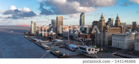 Aerial sunrise view of Liverpool, River Mersey left, skyline right. Royal Liver Building, Cunard Building, Museum of Liverpool, Albert Dock, cranes, wind turbines. Aerial sunrise view of Liverpool, River Mersey left, skyline right. Royal Liver Building, Cunard Building, Museum of Liverpool, Albert Dock, cranes, wind turbines. 143146866