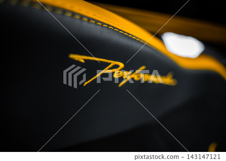Tight interior close up shows Performante script on black leather with yellow stitching. Soft lighting and shallow depth of field suggest an indoor showroom setting. Tight interior close up shows Performante script on black leather with yellow stitching. Soft lighting and shallow depth of field suggest an indoor showroom setting. 143147121