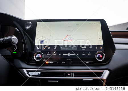 Daytime interior shows landscape touchscreen with red route line, dual rotary climate controls, metallic trim, glossy black bezel, and Lexus analog clock at upper left. Daytime interior shows landscape touchscreen with red route line, dual rotary climate controls, metallic trim, glossy black bezel, and Lexus analog clock at upper left. 143147236