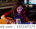 Smiling woman singer recording her song in studio 143147379