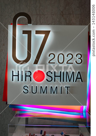 A summit sign reads G7 2023 Hiroshima Summit, the O in Hiroshima is a red circle. Neon accented panels stand in a public event space in Hiroshima, Japan. A summit sign reads G7 2023 Hiroshima Summit, the O in Hiroshima is a red circle. Neon accented panels stand in a public event space in Hiroshima, Japan. 143148006