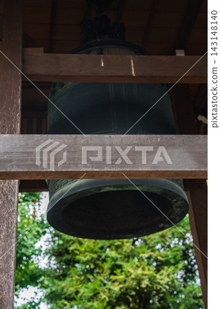 A large bronze bonsho hangs in a wooden belfry in Tokyo, close view shows patina and form, beams frame the bell, soft light suggests ritual use and quiet focus A large bronze bonsho hangs in a wooden belfry in Tokyo, close view shows patina and form, beams frame the bell, soft light suggests ritual use and quiet focus 143148140