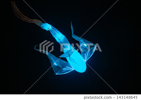 A glowing kite like sea creature sculpture floats at night in Riga, Latvia. Cyan and blue lights reveal fins, tail, and segments, conveying motion during Staro Riga 2025. A glowing kite like sea creature sculpture floats at night in Riga, Latvia. Cyan and blue lights reveal fins, tail, and segments, conveying motion during Staro Riga 2025. 143148645