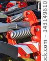 Steel gray spring as part of red heavy agricultural, industrial machine. Technology 143149610