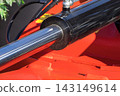 Black piston or actuator in red pneumatic or hydraulic machine. Technology 143149614