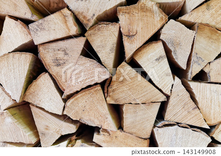 Neatly stacked seasoned firewood logs of hornbeam arranged in triangular ends Neatly stacked seasoned firewood logs of hornbeam arranged in triangular ends 143149908