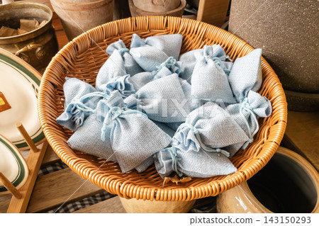 Small light blue linen sachet bags in a wicker basket on display Small light blue linen sachet bags in a wicker basket on display 143150293