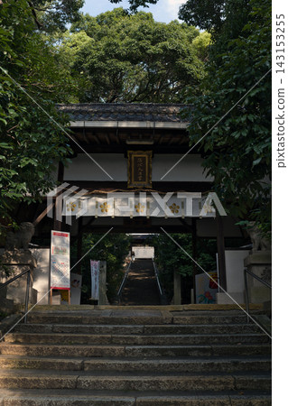 The main gate and stone steps leading to Sada Shrine, surrounded by trees. 143153255