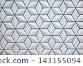A wall with a geometric pattern of white three-dimensional tiles and blue grout. 143155094