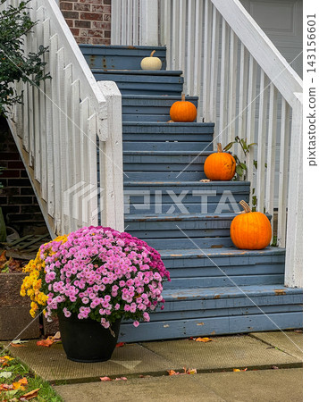 Autumn porch entrance decorated with pumpkins and seasonal chrysanthemums on wooden stairs Autumn porch entrance decorated with pumpkins and seasonal chrysanthemums on wooden stairs 143156601