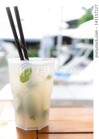A Mojito cocktail enjoyed by the poolside at a resort hotel on a hot summer day. A Mojito cocktail enjoyed by the poolside at a resort hotel on a hot summer day. 143157127