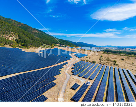 Solar panels installed in a large field situated in a mountainous area under a clear blue sky Solar panels installed in a large field situated in a mountainous area under a clear blue sky 143158321