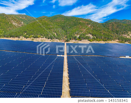 Solar panel field located in a mountainous area under blue sky with few clouds Solar panel field located in a mountainous area under blue sky with few clouds 143158341