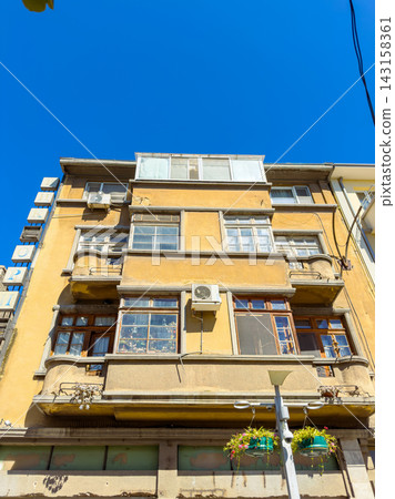 Building with multiple windows and air conditioning units in a city on a clear day 143158361