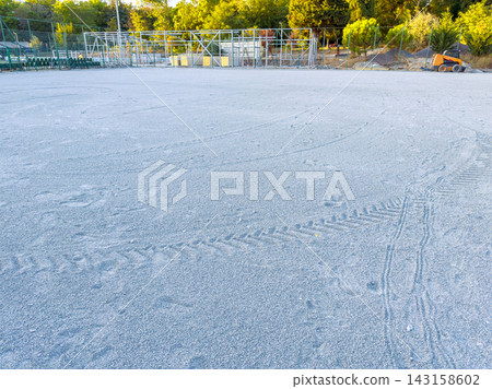 Ground covered with fine gray sand in a construction area near trees in a quiet location during the late afternoon Ground covered with fine gray sand in a construction area near trees in a quiet location during the late afternoon 143158602