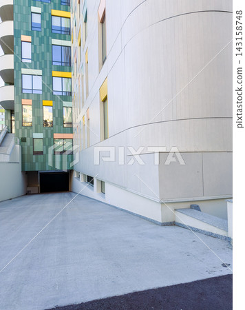 Modern building with a parking entrance and colorful facade in an urban area Modern building with a parking entrance and colorful facade in an urban area 143158748