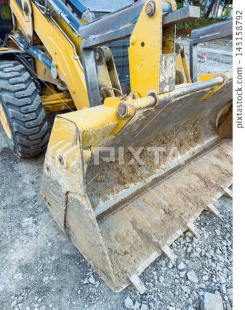 Excavator working on a construction site during the day in an urban area Excavator working on a construction site during the day in an urban area 143158792