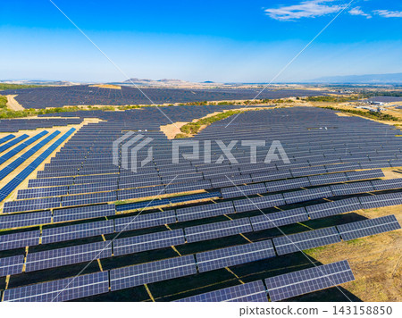 Solar panels covering large area in a renewable energy field near a city on a clear day Solar panels covering large area in a renewable energy field near a city on a clear day 143158850