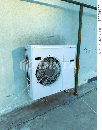 Air conditioning unit mounted on a wall in an urban outdoor setting during daylight hours Air conditioning unit mounted on a wall in an urban outdoor setting during daylight hours 143159061