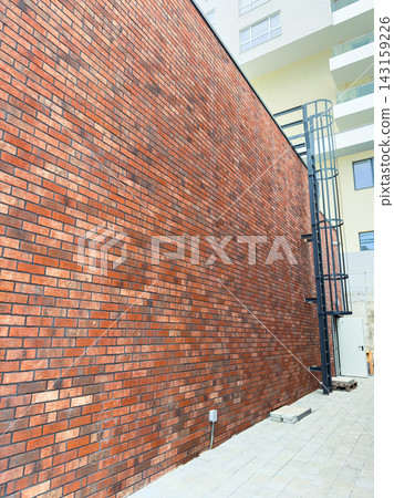 Brick wall with metal structure in urban setting during daylight hours Brick wall with metal structure in urban setting during daylight hours 143159226