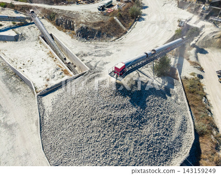 Granite quarry site with machinery processing rock in a busy operation during daytime Granite quarry site with machinery processing rock in a busy operation during daytime 143159249
