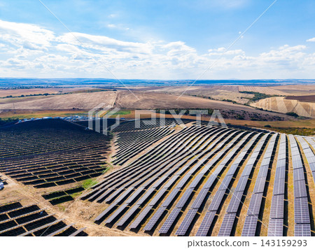 Solar panel field in an open area with blue sky and clouds during the day in a rural location Solar panel field in an open area with blue sky and clouds during the day in a rural location 143159293