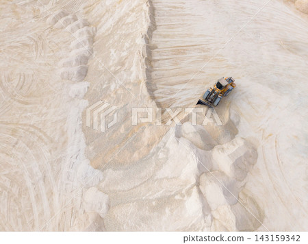 Heavy machinery operates in a quarry to move and process materials during daytime activities Heavy machinery operates in a quarry to move and process materials during daytime activities 143159342
