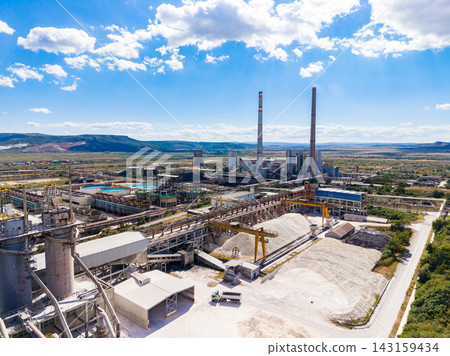 Power plant in operation with machinery and smokestacks under a blue sky in a vast landscape Power plant in operation with machinery and smokestacks under a blue sky in a vast landscape 143159434