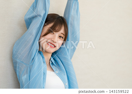 A woman stretches, enjoying the refreshing feeling with her arms outstretched. A woman stretches, enjoying the refreshing feeling with her arms outstretched. 143159522