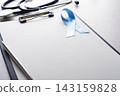 Stethoscope and Blue Prostate Cancer Awareness Ribbon on Clipboard in Medical Office 143159828