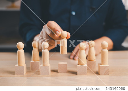 Hand lifts a wooden figure above blocks with other people, representing recruitment, candidate selection, employee promotion, talent choice, ranking, career advancement, 143160068