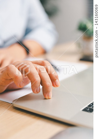 Close-up of office worker using laptop touchpad with finger at a modern desk, representing digital work, computer navigation, business productivity, workplace technology Close-up of office worker using laptop touchpad with finger at a modern desk, representing digital work, computer navigation, business productivity, workplace technology 143160069